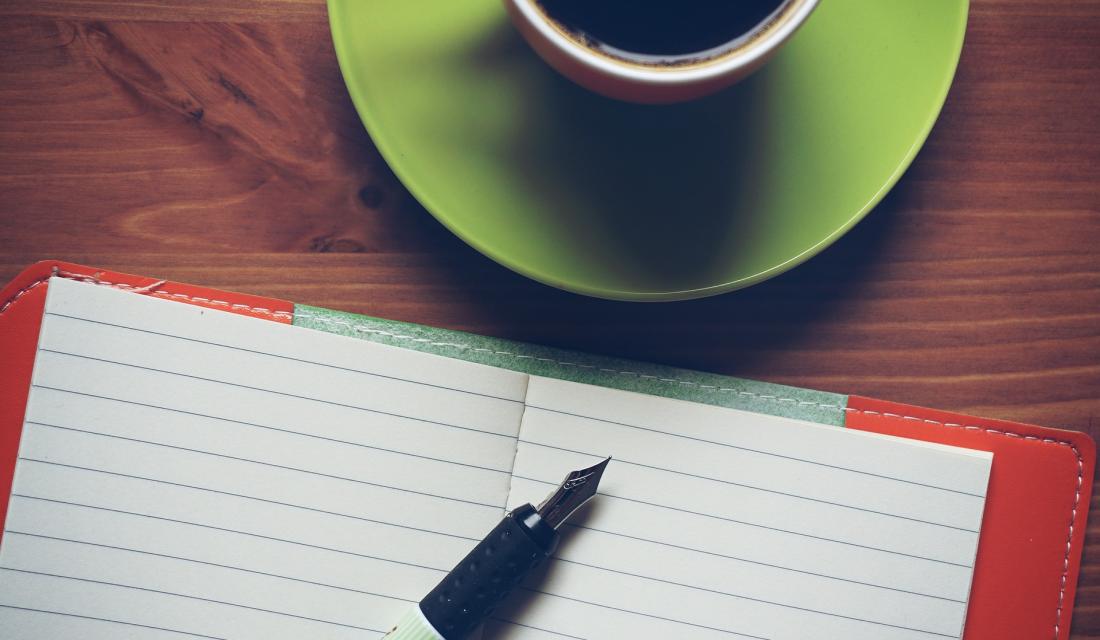 Notizbuch mit Füller, Tasse Kaffee