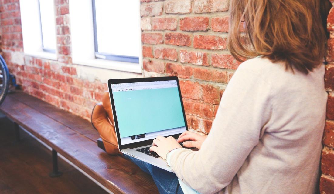 junge Frau arbeitet am Laptop, Rückansicht