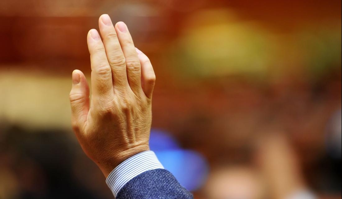 Hand eines Mannes, zur Abstimmung erhoben