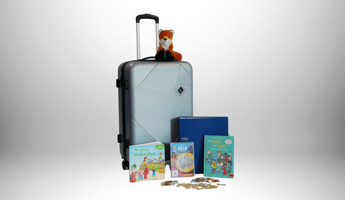 Der graue Finanzkoffer mit allerlei Material, ein Plüschtierfuchs und ein Spiel für Kinder