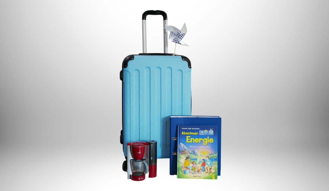 Der blaue Energiekoffer mit exemplarischem Material, Bücher, Ordner, Spielzeugkaffeemaschine und gebasteltes Windrad