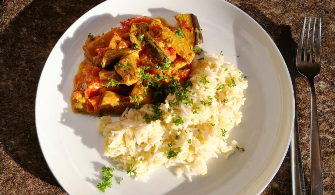 Auberginen in Senfsauce und Reis auf einem Teller