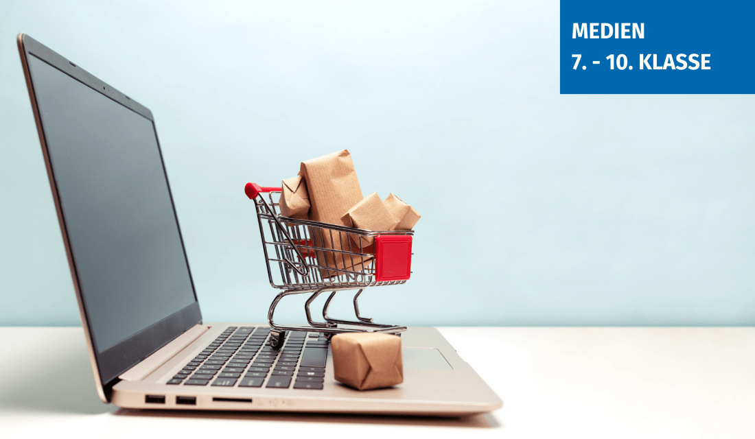 Ein aufgeklappter Laptop mit einem kleinen, vollen Einkaufswagen auf der Tastatur