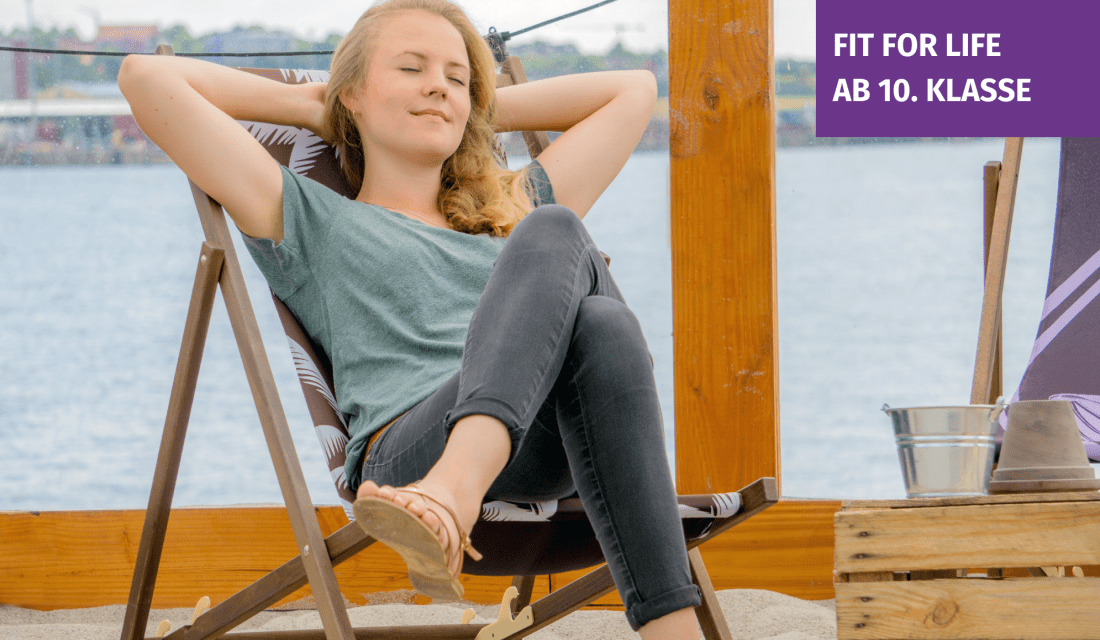 Laura liegt in einem Liegestuhl am Strand und genießt die Sonne