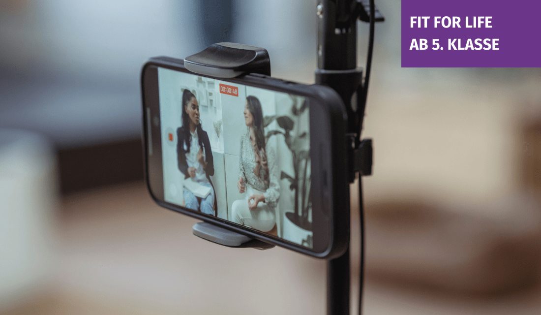 Ein Smartphone in einem Stativ auf dem eine Videoaufnahme zu sehen ist