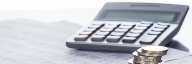 Münzstapel und Taschenrechner