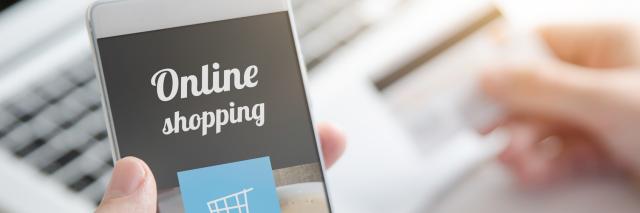 Jemand kauft am Laptop und Smartphone online etwas ein.