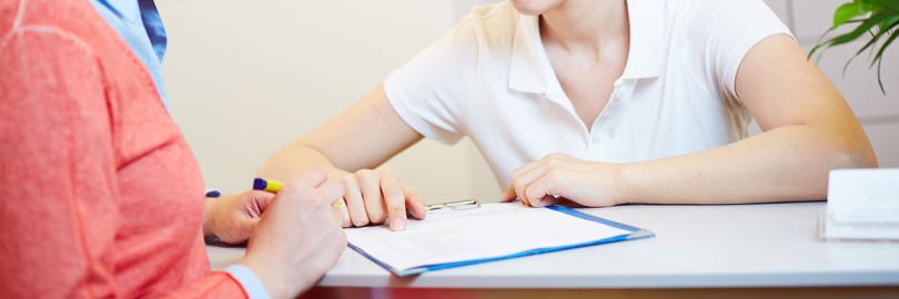 Patientin in der Praxis soll ein Formular unterschreiben