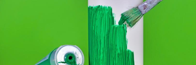 Grün angemalte Flasche mit Pinsel und Farbtube als Symbolbild für Greenwashing