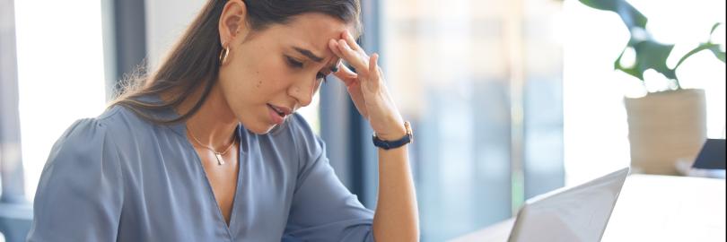 Schmuckbild: Frau mit besorgtem Gesichtsausdruck hält eine Kreditkarte in der Hand, während sie sich offensichtlich über ein finanzielles Problem oder einen Betrugsfall im Zusammenhang mit Online-Zahlungen oder Bankgeschäften ärgert.