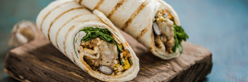 zwei Wraps mit Füllung auf einem Holztablette 