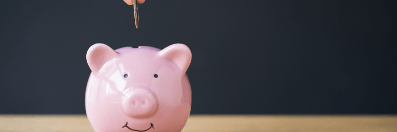 Ein Sparschwein wird mit einer Münze befüllt