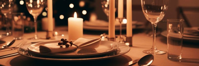 ein mit Geschirr gedeckter Festtagstisch, im Hintergrund steht ein Weihnachtsbaum.