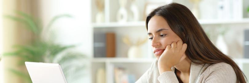 Gelangweilte Person vor einem Laptop