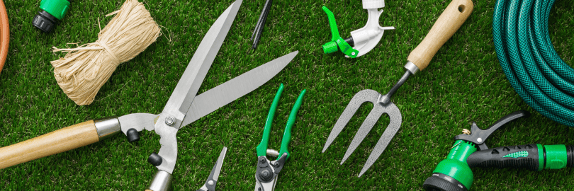 verschieden Gartenwerkzeuge liegen auf dem Rasen