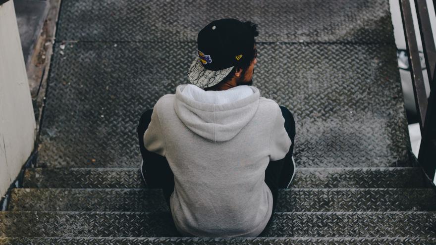 junger Mann sitzt auf einer Treppe