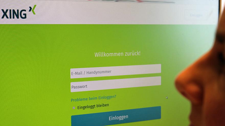Frau betrachtet Online-Seite xing.de auf PC-Bildschirm