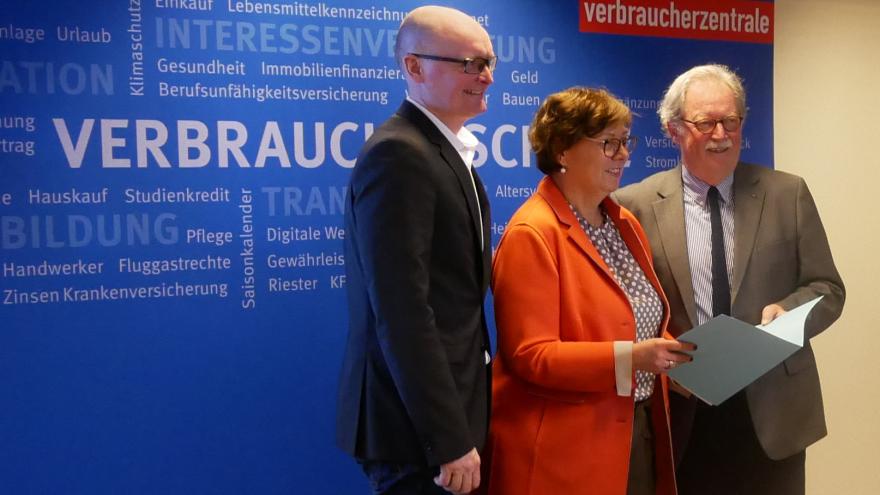 Die schleswig-holsteinische Verbraucherschutzministerin Dr. Sabine Sütterlin-Waack (Mitte) überreicht einen Zuwendungsbescheid an den VZSH-Verwaltungsratsvorsitzenden Jochem Schlotmann (rechts) und VZSH-Vorstand Stefan Bock (links).