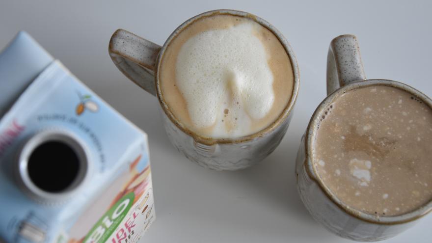 zwei Becher Kaffee - mit Milchschaum und geflockter Milch