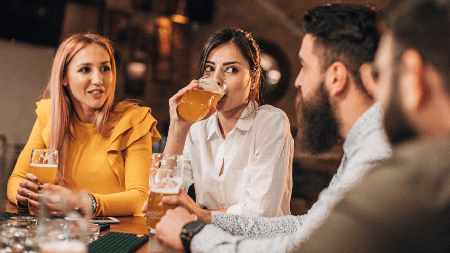 Vier Leute trinken ein Bier in einer Bar. 