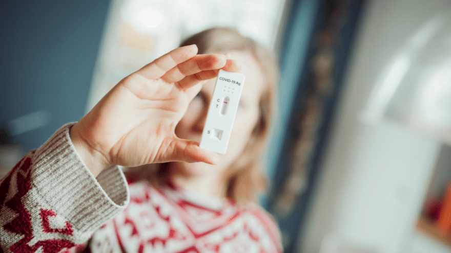 junge Frau hält eine Testkassette vor ihr Gesicht