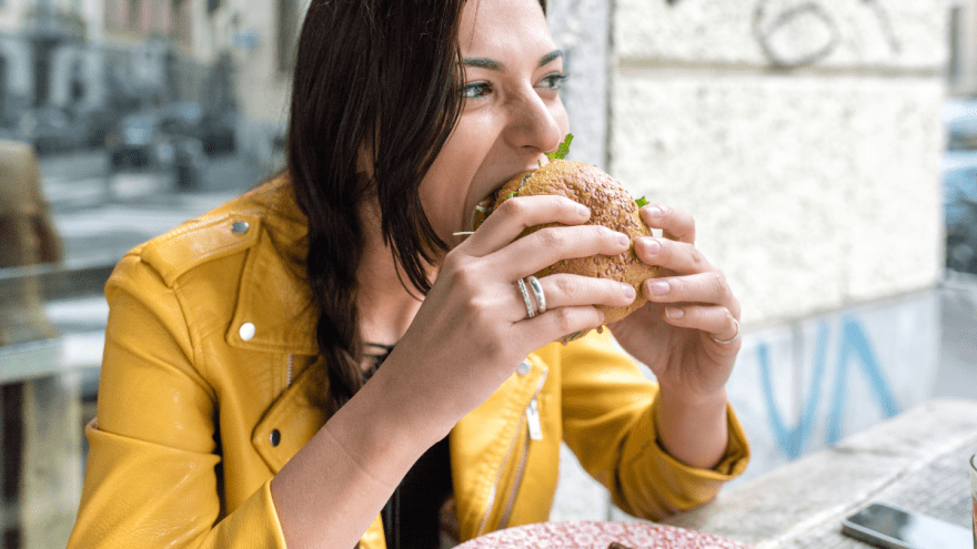 junge Frau beisst in einen Burger