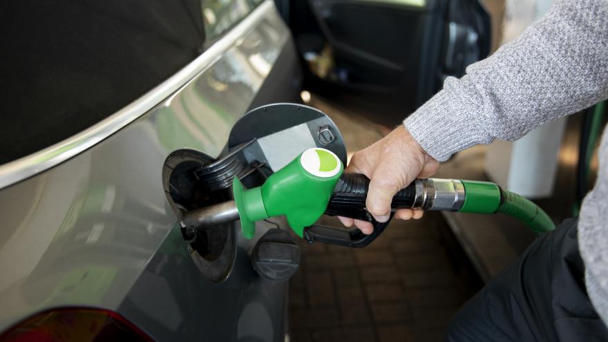 Eine Hand hält an einer Tankstelle eine Zapfpistole in die Tanköffnung