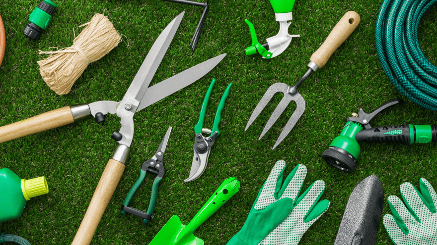 verschieden Gartenwerkzeuge liegen auf dem Rasen