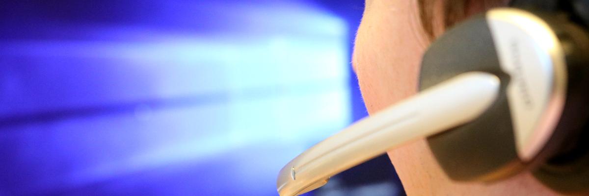 Mann mit Headset vor PC-Bildschirm