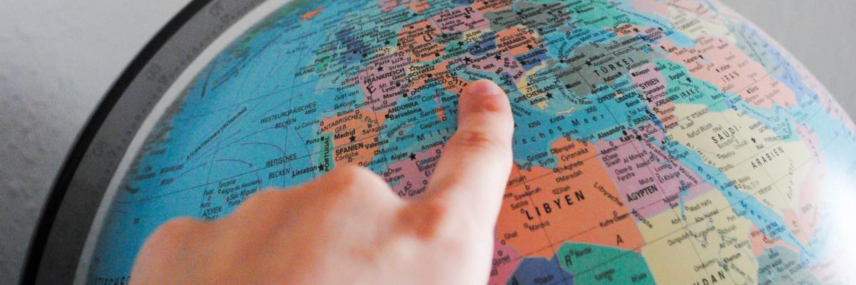 Reise mit dem Zeigefinger über einen Globus