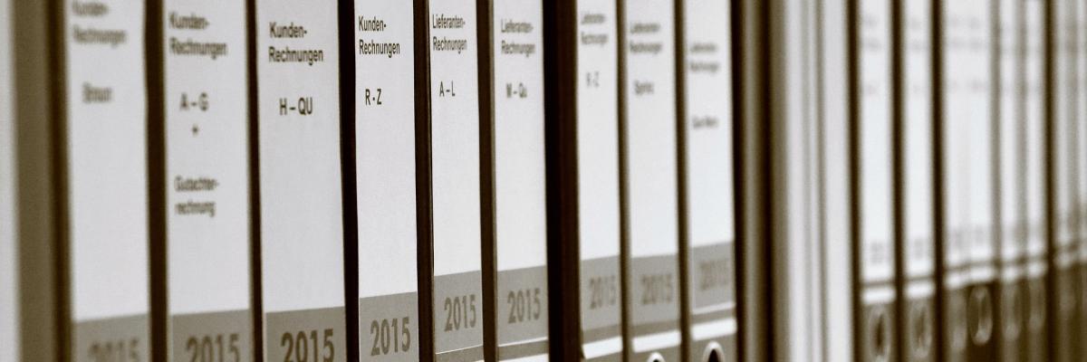Aktenordner stehen aufgereiht in einem Aktenschrank