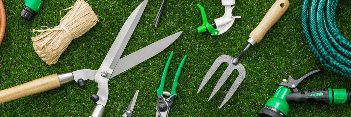 verschieden Gartenwerkzeuge liegen auf dem Rasen