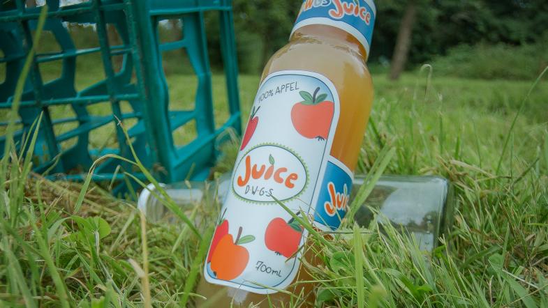 Flasche Apfelsaft im Gras