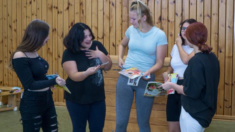 Vier Mädchen im Teenageralter in einer Sporthalle lachen und reden
