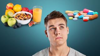 Ein Mann überlegt, ob er zu Nahrungsergänzungsmitteln oder zu Obst greifen soll.