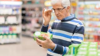 Ein Mann schaut die Verpackung von Lebensmitteln