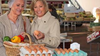 Zwei Damen kaufen Eier auf dem Markt