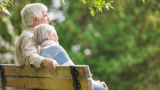 Ein älteres Paar sitzt auf einer Parkbank