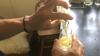 Ingwershot wird aus einer kleinen Flasche in ein Glas gefüllt