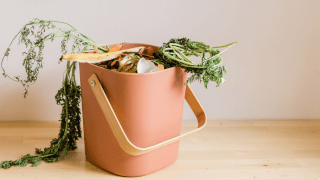 ein moderner Abfalleimer mit Henkel gefüllt mit Lebensmitteln