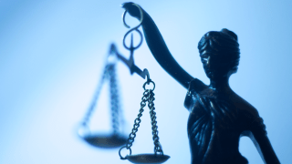 Nahaufnahme der Justizia mit verbundenen Augen und der Wagschale in einer erhobenen Hand