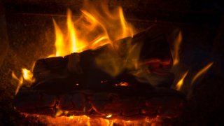 Zwei Holzscheite brennen in einem Ofen