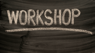 schwarze Tafel auf der mit weißer Kreide Workshop geschrieben steht