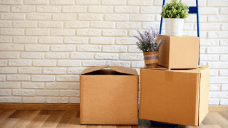 Umzugskartons stehen in einem leeren Zimmer