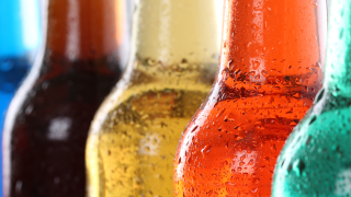 mehrere Flaschen mit Limonade und Energydrinks in einer Reihe