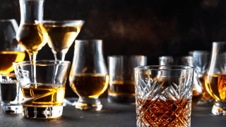 Zahlreiche halb gefüllte Gläser in unterschiedlichen Formen.