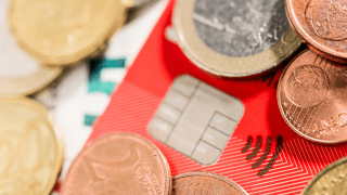 Geldmünzen liegen auf einer Kreditkarte