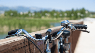 Ein Fahrrad steht an einem Geländer angelehnt auf einer Brücke.