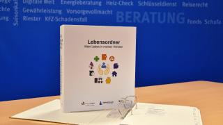 Der Lebensordner steht aufrecht vor einer blauen Hintergrund Wand