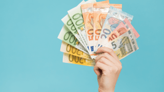 Eine Hand voller aufgefächerter Geldscheine